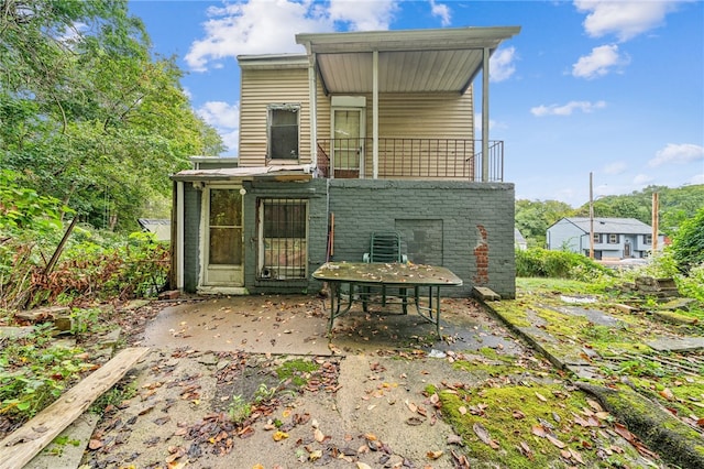 rear view of house featuring a patio and a balcony