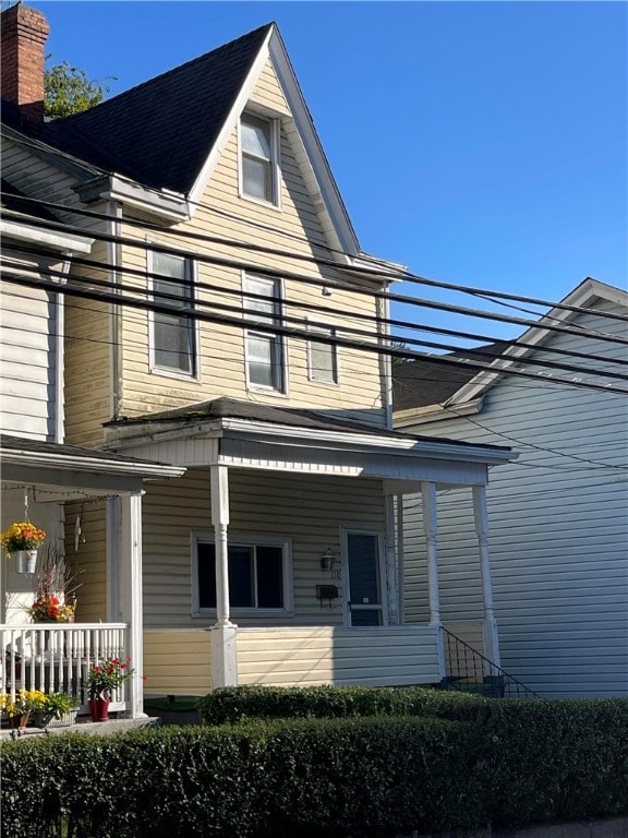 rear view of house featuring covered porch