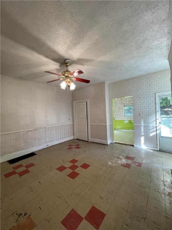 unfurnished room featuring ceiling fan and a textured ceiling