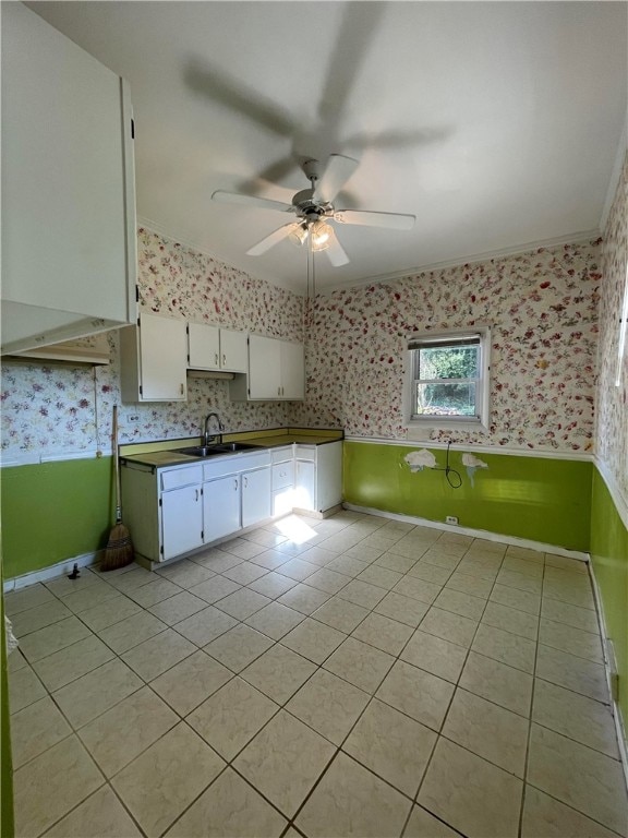 kitchen with crown molding, sink, light tile patterned flooring, white cabinetry, and ceiling fan