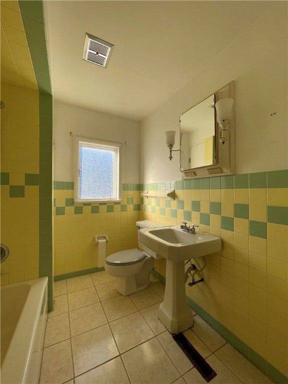 bathroom featuring tile walls, plus walk in shower, toilet, and tile patterned flooring