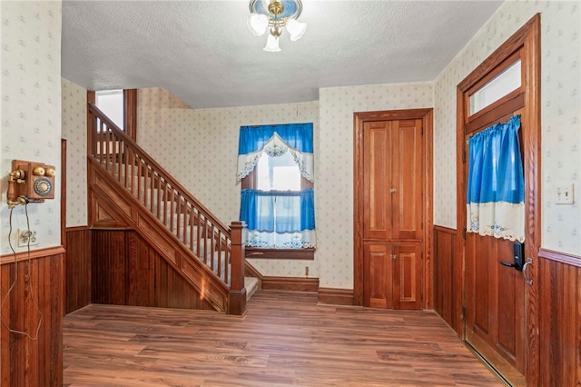 foyer entrance with hardwood / wood-style floors and a textured ceiling