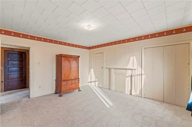 unfurnished bedroom with light colored carpet and a closet