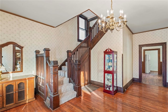 stairway with a chandelier, crown molding, and wood-type flooring