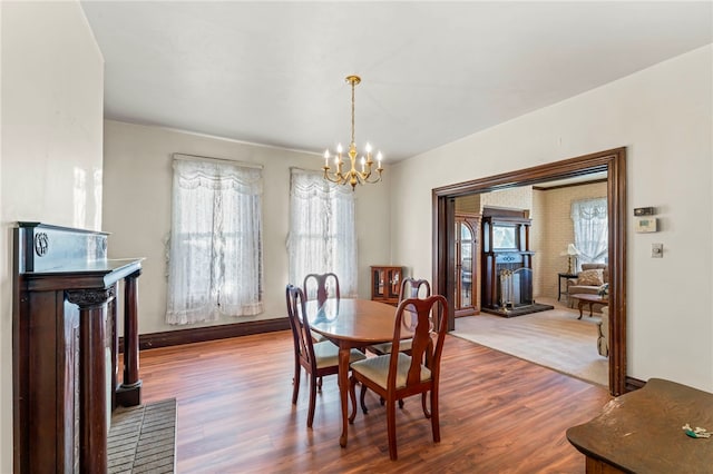 dining space with wood-type flooring and a notable chandelier