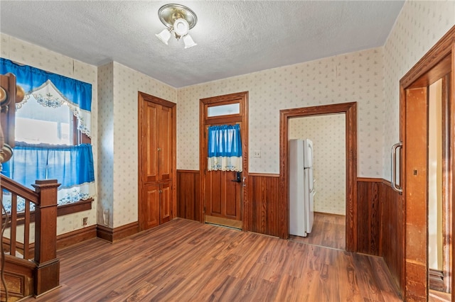 entryway with dark wood-type flooring and a textured ceiling