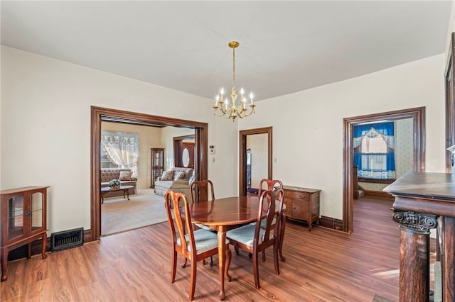 dining room with hardwood / wood-style floors and a chandelier