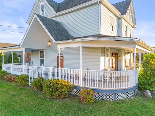 back of house with a lawn and covered porch