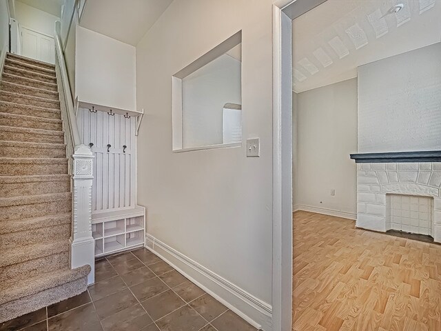 mudroom with hardwood / wood-style floors and a fireplace