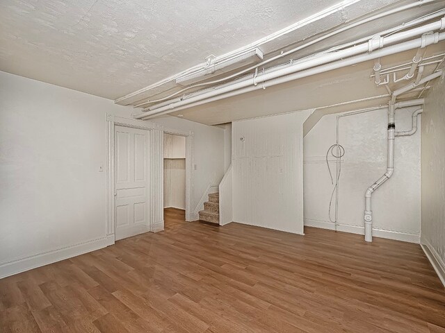 basement featuring hardwood / wood-style floors and a textured ceiling