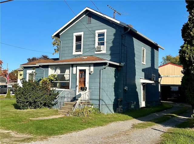 view of front of house featuring a front lawn and cooling unit