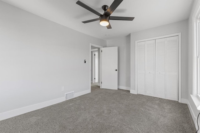 unfurnished bedroom featuring carpet floors, a closet, and ceiling fan