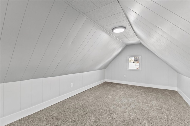 bonus room with vaulted ceiling and carpet floors