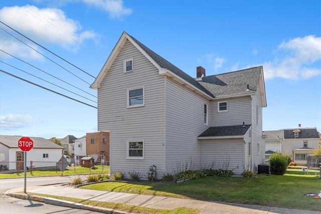 view of home's exterior with central AC unit and a lawn