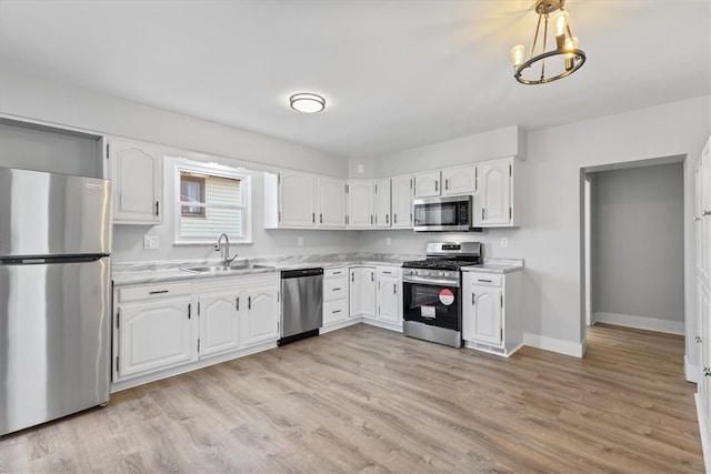 kitchen with sink, white cabinetry, stainless steel appliances, and light wood-type flooring