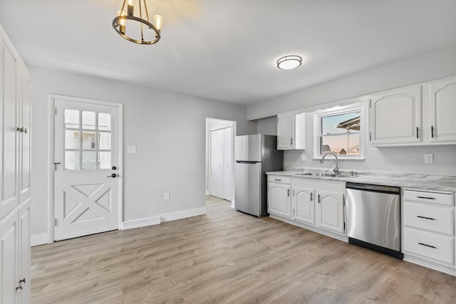 kitchen with appliances with stainless steel finishes, light hardwood / wood-style flooring, white cabinets, and sink