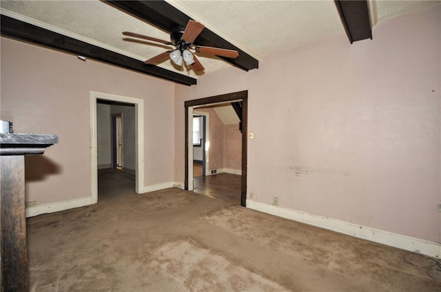 interior space featuring a textured ceiling, beam ceiling, and dark carpet