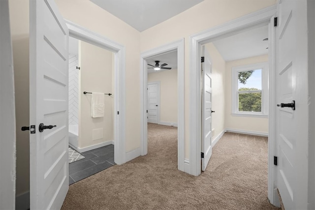 hall featuring dark colored carpet