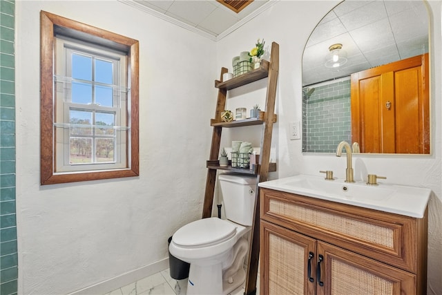 bathroom with vanity, crown molding, and toilet