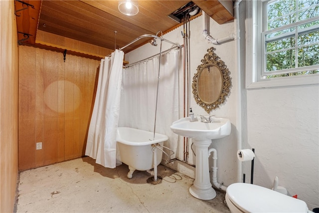 bathroom with shower / bathtub combination with curtain, toilet, concrete floors, wooden ceiling, and wood walls