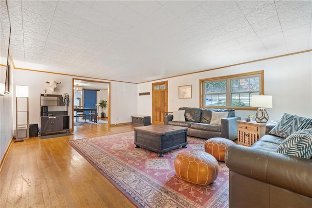 living room featuring crown molding and hardwood / wood-style flooring