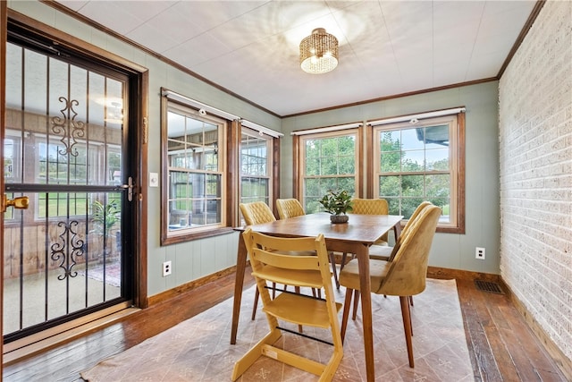 dining space featuring crown molding and wood-type flooring