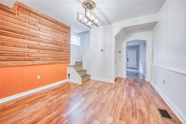 unfurnished living room featuring light hardwood / wood-style floors and a notable chandelier