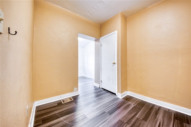 empty room with dark wood-type flooring