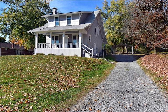 view of front of house with a porch, a front lawn, and a carport