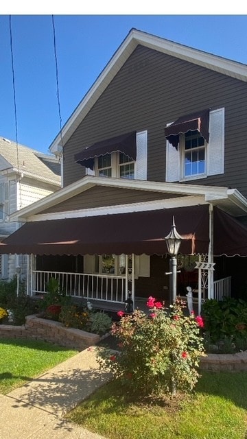 rear view of property featuring covered porch