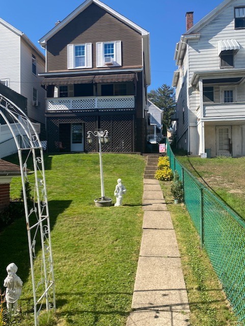 rear view of property featuring a yard