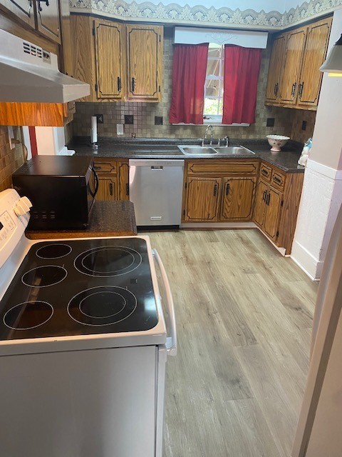 kitchen with sink, light wood-type flooring, backsplash, white range with electric cooktop, and stainless steel dishwasher