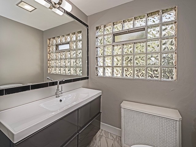 bathroom featuring vanity, toilet, and radiator