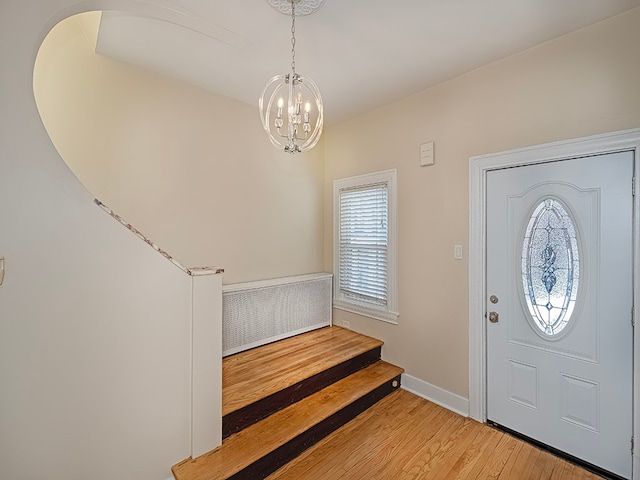 entryway with an inviting chandelier and light hardwood / wood-style floors