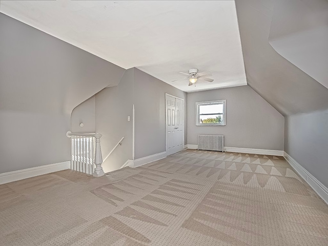 bonus room with light carpet, vaulted ceiling, radiator heating unit, and ceiling fan