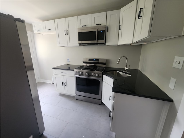 kitchen with white cabinets, stainless steel appliances, sink, and light tile patterned floors