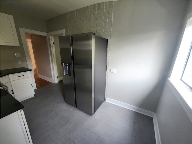 kitchen with stainless steel fridge with ice dispenser and white cabinetry