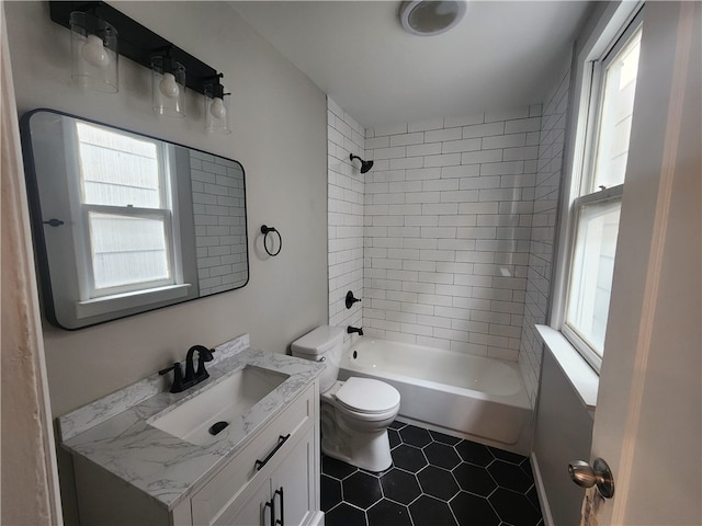 full bathroom featuring toilet, tiled shower / bath combo, vanity, and tile patterned floors