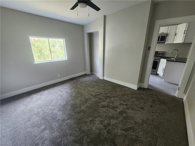 carpeted empty room with sink and ceiling fan