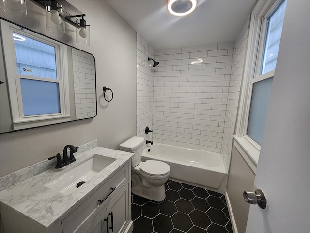 full bathroom featuring tiled shower / bath, vanity, toilet, and tile patterned floors