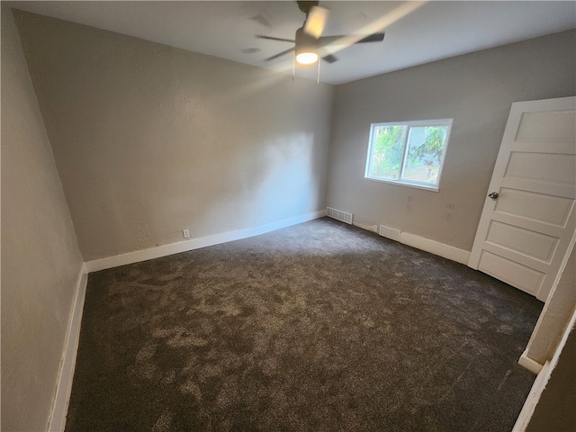 unfurnished room with ceiling fan and dark colored carpet