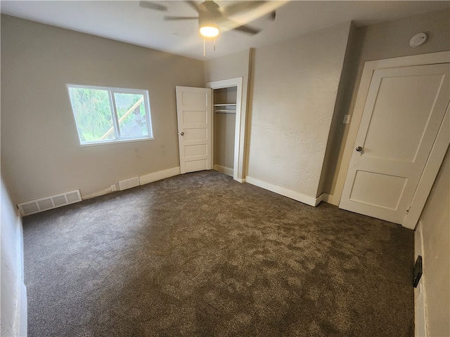 unfurnished bedroom with a closet, ceiling fan, and dark colored carpet