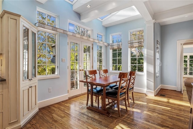 sunroom / solarium featuring a healthy amount of sunlight, beam ceiling, and french doors