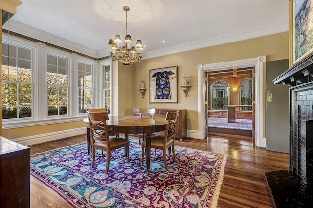 dining room with ornamental molding, dark hardwood / wood-style floors, and a notable chandelier