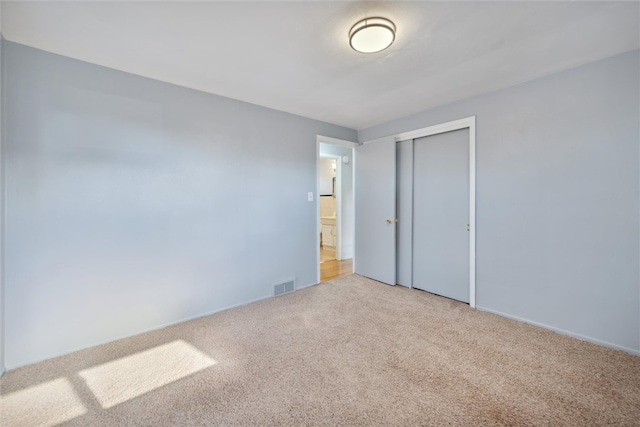 unfurnished bedroom with a closet and carpet floors