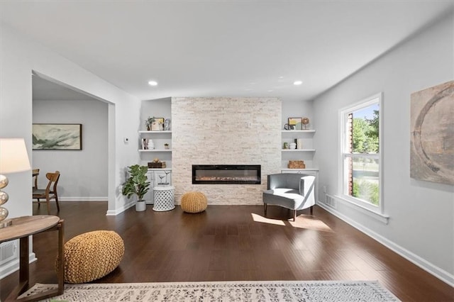 interior space with built in features, dark hardwood / wood-style flooring, and a fireplace