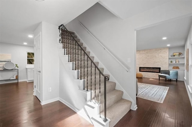 staircase featuring hardwood / wood-style floors and a fireplace