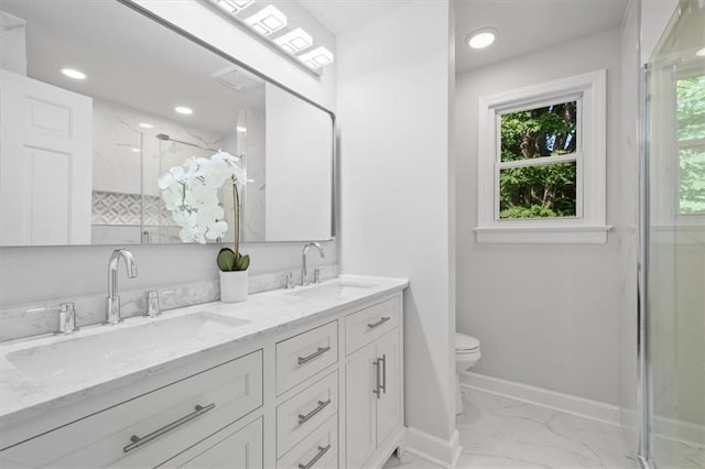 bathroom featuring toilet, vanity, and a shower with door