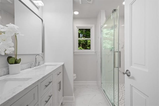 bathroom featuring vanity, toilet, and a shower with shower door