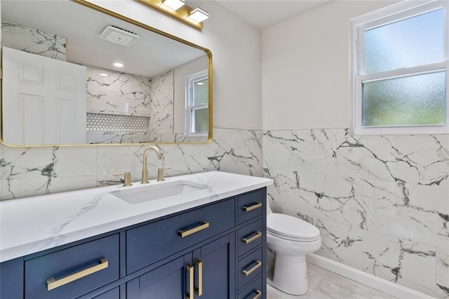 bathroom featuring tile walls, vanity, toilet, and walk in shower